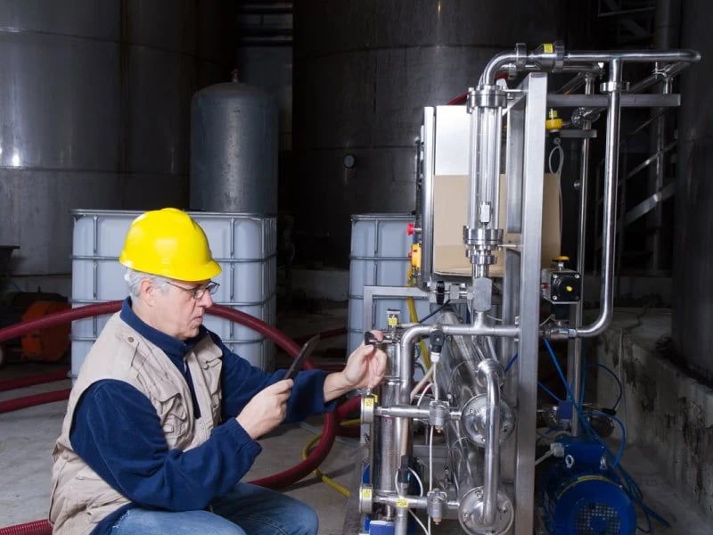 employee inspecting valve